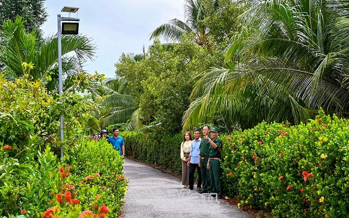 Các thành viên Uỷ ban MTTQ Việt Nam xã Vĩnh Thanh cùng người dân tham quan công trình “Thắp sáng đường quê” ở ấp Mỹ Trinh.