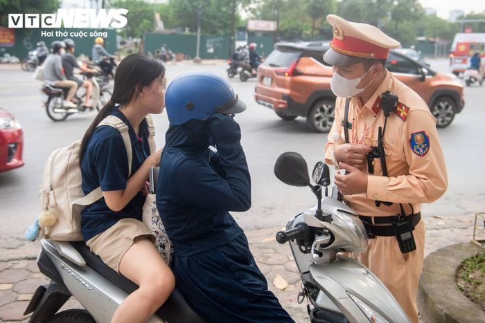 Khoảng 5 phút sau, tổ công tác tiếp tục phát hiện một phụ huynh chở con gái phía sau nhưng không đội mũ bảo hiểm. 