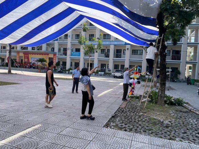 Giáo viên, học sinh Trường THCS Ninh Hiệp tham gia cắt tỉa cây xanh, dọn vệ sinh trường học để chuẩn bị cho lễ khai giảng năm học mới. Ảnh: Nguyễn Thủy