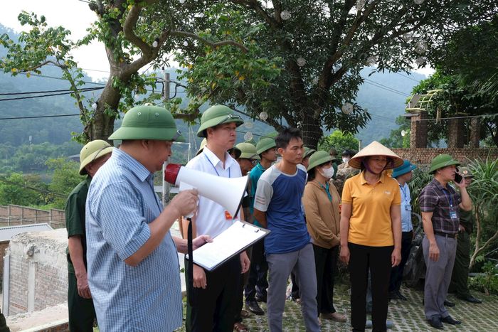 Lực lượng chức năng công bố quyết định cưỡng chế cho người dân rõ, trước khi triển khai biện pháp cưỡng chế phá dỡ công trình vi phạm. Ảnh: Sỹ Hào