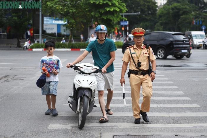 Vội đưa con đến trường tổng duyệt khai giảng, phụ huynh đội mũ bảo hiểm cho mình nhưng lại quên mũ bảo hiểm cho con. (Ảnh Thành Long)