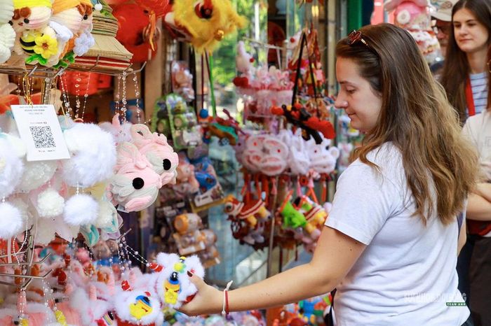 Một du khách nước ngoài chăm chú ngắm những món đồ chơi. Ảnh: T.Anh 