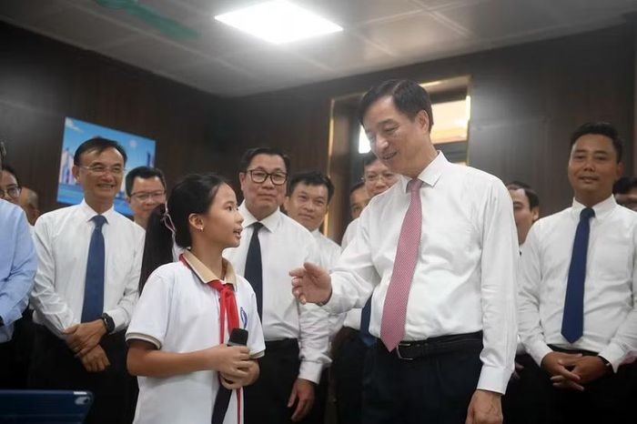 Đồng chí Nguyễn Duy Ngọc ân cần tương tác, động viên các em học sinh đang thực hành điều khiển robot trên sa bàn giao thông mô phỏng.