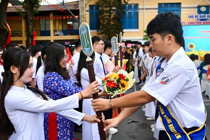  Học sinh khối 12 thực hiện nghi thức trao hoa cho giáo viên chủ nhiệm và trao bảng tên lớp cho lớp trưởng các lớp khối 10. Những bó hoa thay lời chúc mừng, đồng thời thể hiện tình cảm của học sinh khối 12 dành cho các học sinh mới trong năm học đầu tiên tại trường THPT Trần Khai Nguyên. Nghi thức trao bảng tên lớp cũng đánh dấu thời điểm 716 học sinh khối 10 chính thức trở thành một phần không thể thiếu của trường. 