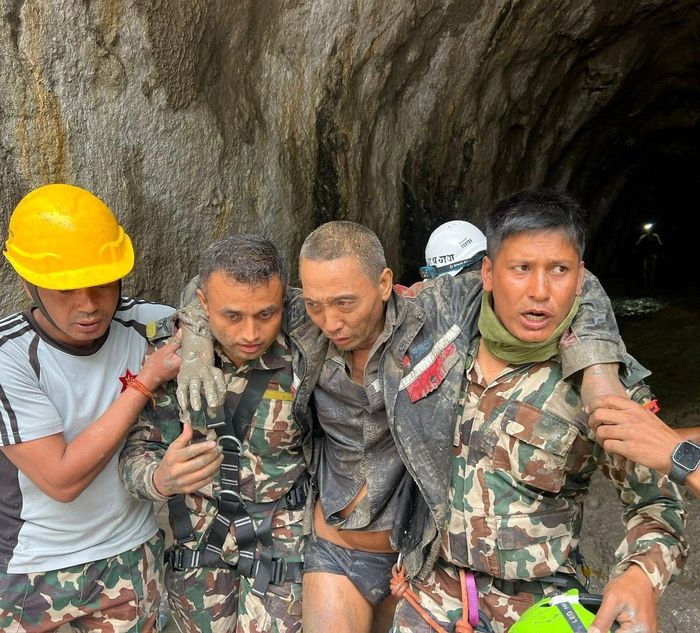 Các thành viên của đội tìm kiếm và cứu hộ thuộc Quân đội Nepal đang khiêng một công dân Trung Quốc khỏi một đường hầm tại Dự án Thủy điện Upper Trishuli-1 ngày 5/9 sau trận lũ lụt và sạt lở đất. Ảnh: Reuters.