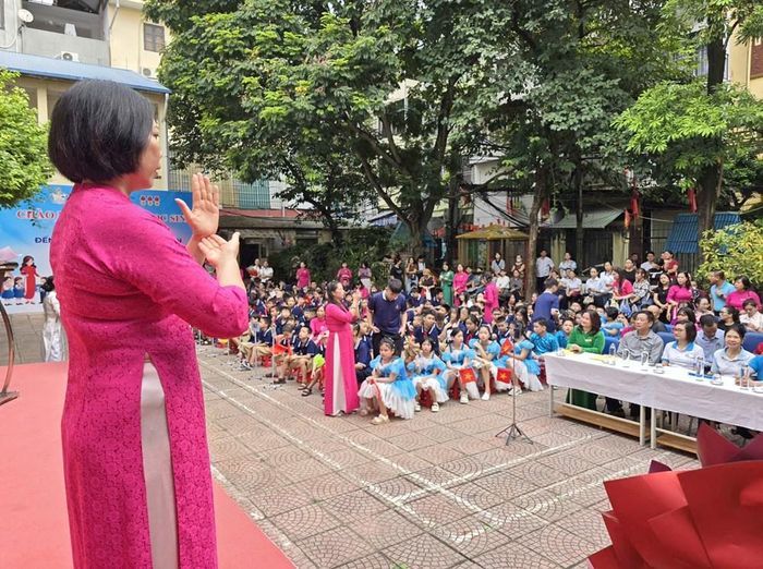 Cô giáo dùng ngôn ngữ ký hiệu "phiên dịch" những lời phát biểu tới học sinh trong Lễ khai giảng