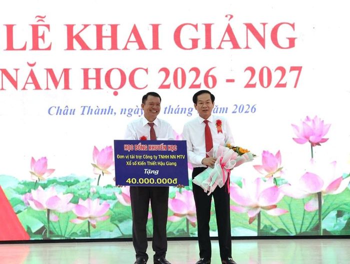 Ông Đỗ Thanh Bình, Bí thư Thành ủy Cần Thơ (bên phải) trao học bổng cho đại diện nhà trường, dành tặng các em học sinh Trường THCS và THPT Ngã Sáu