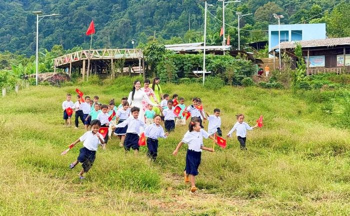Sau lễ khai giảng, 3 cô giáo đưa học sinh ra khoảng cỏ phía trước điểm trường. Những đứa trẻ tay cầm cờ, chạy tung tăng giữa màu xanh của núi rừng