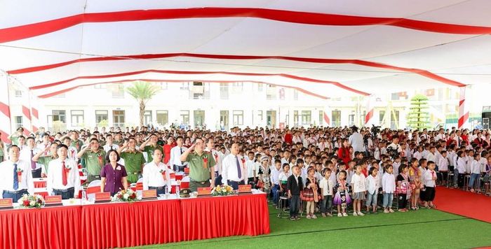 Các đại biểu cùng thầy, cô giáo và học sinh thực hiện nghi lễ chào cờ, hát Quốc ca cùng với các điểm cầu trong cả nước