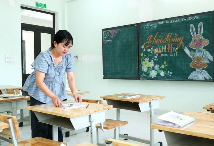 Tranh thủ giờ ra chơi, cô giáo tranh thủ sắp xếp lại vở viết trên bàn học cho các em học sinh lớp 1