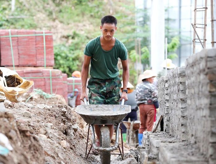 Cán bộ, chiến sĩ tích cực tham gia hỗ trợ thi công, góp sức người cùng các lực lượng đẩy nhanh tiến độ, sớm hoàn thiện ngôi trường, đáp ứng nhu cầu học tập của học sinh vùng biên