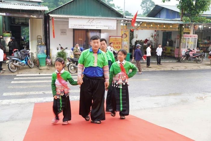 Phụ huynh và học sinh ở bản Mông Mùa Xuân, xã Sơn Thủy hào hứng có mặt từ sáng sớm tại Trường Phổ thông nội trú Tiểu học và Trung học cơ sở Sơn Thủy, xã Sơn Thủy. Ảnh: Khiếu Tư - TTXVN