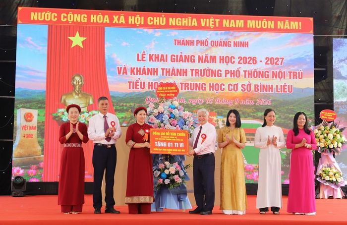 Phó Chủ tịch Thường trực Quốc hội Đỗ Văn Chiến trao tặng ti vi và lẵng hoa chúc mừng Trường Phổ thông Nội trú Tiểu học và THCS Bình Liêu nhân ngày khai trường. Ảnh: Thanh Vân - TTXVN