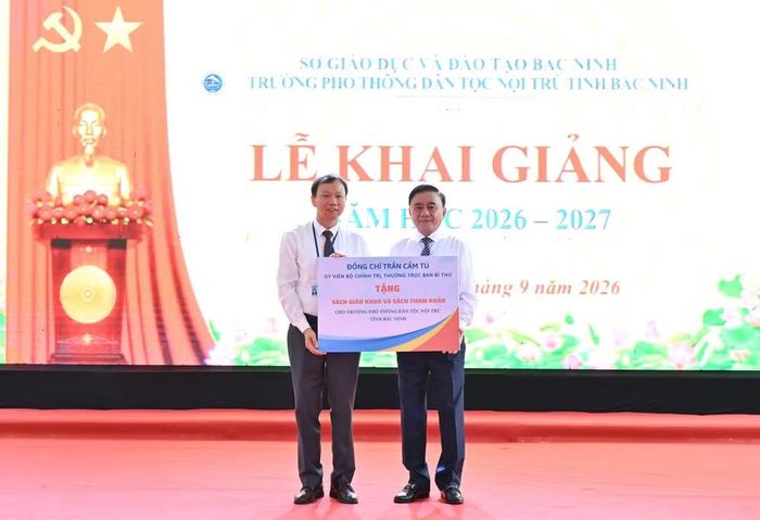 Thường trực Ban Bí thư Trần Cẩm Tú trao quà tặng nhà trường và các em học sinh. (Ảnh: THỦY NGUYÊN)