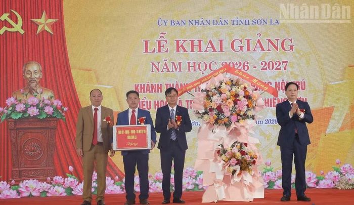 Đồng chí Hoàng Văn Nghiệm, Ủy viên Trung ương Đảng, Bí thư Tỉnh ủy Sơn La tặng hoa và quà chúc mừng thầy trò Trường phổ thông nội trú liên cấp tiểu học và trung học cơ sở Chiềng Sơn. (Ảnh: QUỐC TUẤN)