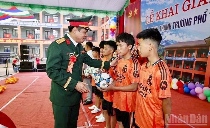 Đại tá Trịnh Đức Thiêm, Chỉ huy trưởng Bộ Chỉ huy quân sự tỉnh Điện Biên, trao quà của đồng chí Tổng Bí thư, Chủ tịch nước Tô Lâm gửi tặng học sinh Trường phổ thông nội trú liên cấp tại Sín Thầu. (Ảnh: LÊ LAN)