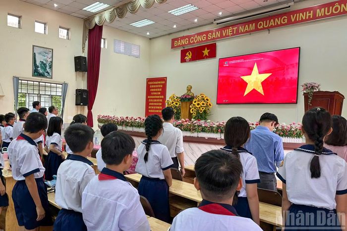 Giáo viên và học sinh Trường tiểu học Phước Long (phân hiệu 1) thực hiện nghi lễ chào cờ khai giảng năm học mới. (Ảnh: QUANG QUÝ)