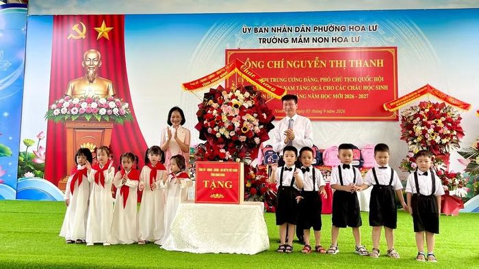 Đồng chí Bí thư Tỉnh ủy Ninh Bình Trần Huy Tuấn tặng hoa và quà cho nhà trường. (Ảnh: YẾN TRINH)