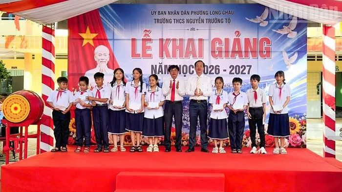 Chủ tịch Ủy ban nhân dân tỉnh Vĩnh Long Trần Trí Quang trao học bổng cho học sinh Trường trung học cơ sở Nguyễn Trường Tộ. (Ảnh: BÁ DŨNG)