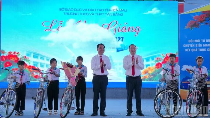 Bí thư Tỉnh ủy Cà Mau Nguyễn Hồ Hải (đứng giữa, bên phải), cùng Phó Bí thư Tỉnh ủy, Chủ tịch Ủy ban nhân dân tỉnh Lữ Quang Ngời (đứng giữa, bên trái) tặng xe đạp hỗ trợ cho học sinh có hoàn cảnh khó khăn khi đến dự Lễ khai giảng. (Ảnh: HỮU TÙNG)