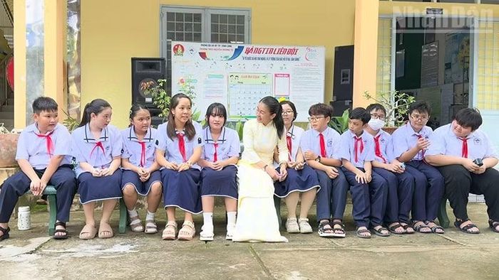Cô ﻿Nguyễn Xuân Mai, Phó Hiệu trưởng Trường trung học phổ thông Nguyễn Trường Tộ, trò chuyện cùng các em học sinh đầu năm mới. (Ảnh: BÁ DŨNG)
