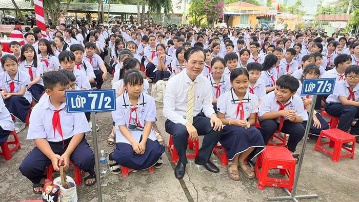 Chủ tịch Ủy ban nhân dân tỉnh Vĩnh Long Trần Trí Quang chụp hình lưu niệm với học sinh Trường trung học cơ sở Nguyễn Trường Tộ. (Ảnh: BÁ DŨNG)
