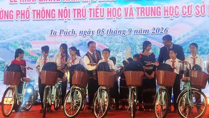 Đồng chí Thái Đại Ngọc tặng xe đạp cho các em học sinh. (Ảnh: PHÚC THẮNG)