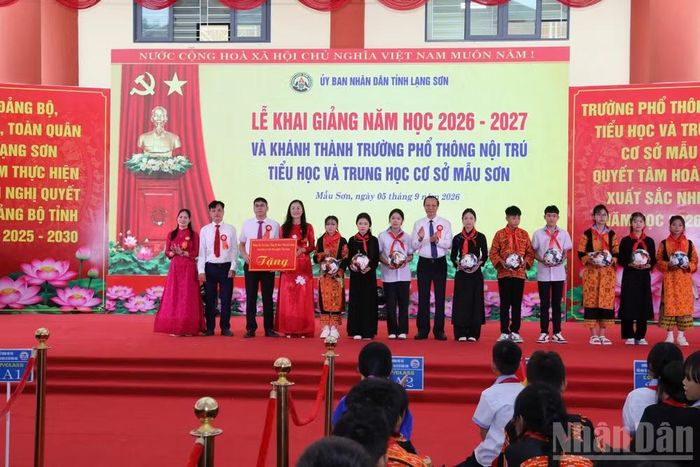 Các đại biểu tặng quà của lãnh đạo Đảng, Nhà nước cho nhà trường. (Ảnh: QUỐC ĐẠT)