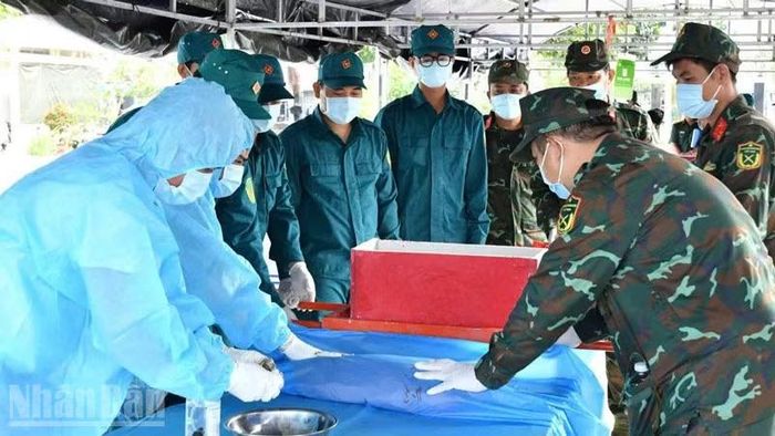 Cán bộ, chiến sĩ thực hiện lấy mẫu ADN. (Ảnh: PHƯƠNG VŨ)