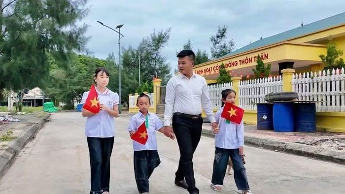 Thầy Trần Văn Luyện, giáo viên Trường tiểu học và trung học cơ sở Thanh Lân cũng các học sinh của mình trong Ngày khai giảng. (Ảnh: THU BÁU)