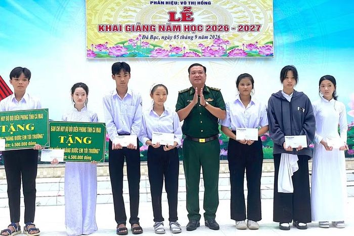 Trung tá Trương Văn Kết, Chính trị viên Đồn Biên phòng Sông Đốc tặng học bổng cho các em học sinh Trung học cơ sở và Trung học phổ thông Khánh Hưng (xã Đá Bạc, tỉnh Cà Mau). (Ảnh: HOÀNG TÁ)