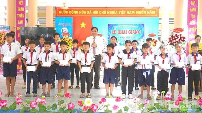 Chủ tịch Ủy ban nhân dân tỉnh Đồng Tháp Phạm Thành Ngại trao học bổng tặng học sinh. (Ảnh: HỮU NGHĨA)