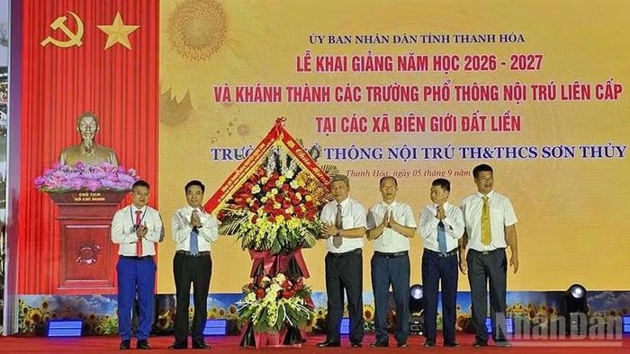 Phó Chủ tịch Quốc hội Nguyễn Doãn Anh trao tặng hoa chúc mừng tập thể giáo viên, học sinh ở xã Sơn Thủy, tỉnh Thanh Hóa. (Ảnh: MAI LUẬN)
