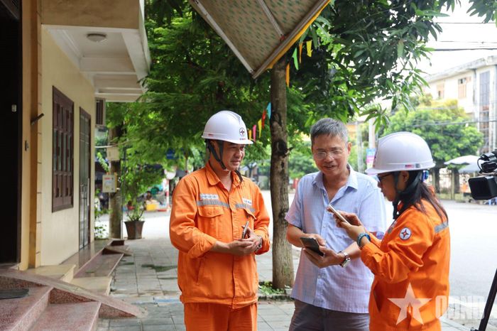 Nhân viên Đội Quản lý Điện lực khu vực Phố Hiến hướng dẫn khách hàng các tiện ích của app EVN CSKH.