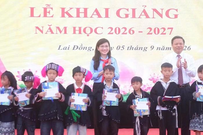 Chị Hồ Hồng Nguyên và ông Phan Trọng Tấn trao học bổng cho học sinh.