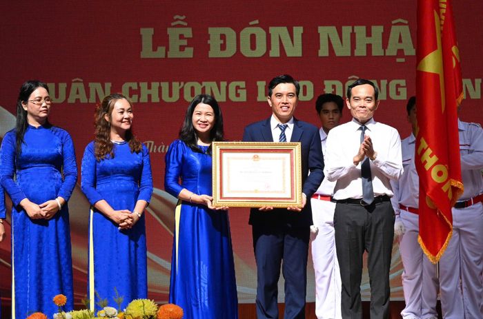 Đồng chí Trần Lưu Quang trao Huân chương Lao động hạng nhì cho Trường THPT Trần Khai Nguyên. Ảnh: VIỆT DŨNG 