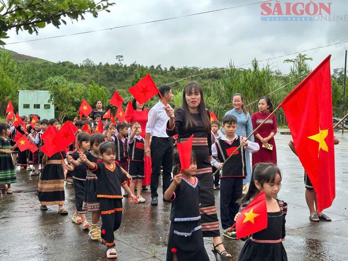  Giáo viên Trường Phổ thông dân tộc bán trú Tiểu học Tu Mơ Rông đón học sinh dự khai giảng. Ảnh: VƯƠNG TRẦN 