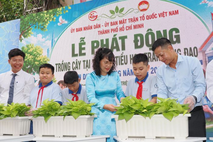 Hiệu trưởng Trường Tiểu học Trần Hưng Đạo Lê Thanh Hương cùng đại biểu và học sinh trồng cây hưởng ứng Chương trình “Vì một Việt Nam xanh” tại lễ khai giảng năm học 2026-2027, sáng 5-9. Ảnh: HOÀNG HÙNG