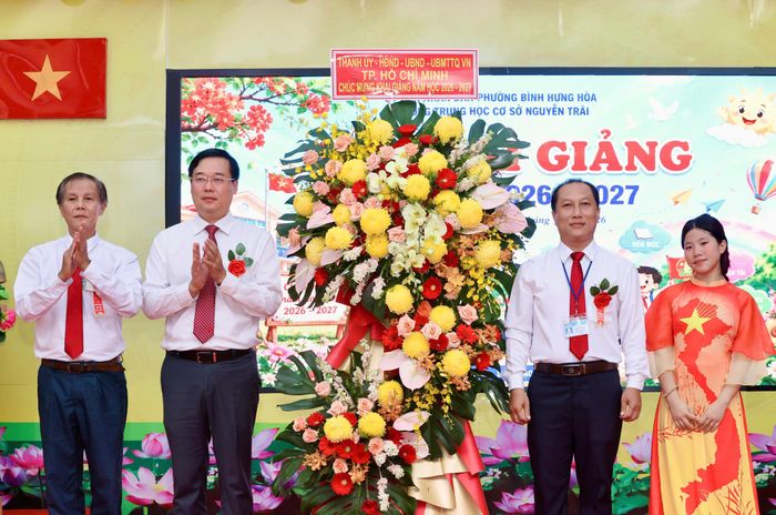 Đồng chí Lê Quốc Phong tặng hoa chúc mừng lễ khai giảng năm học mới. Ảnh: HOÀNG TRIỀU
