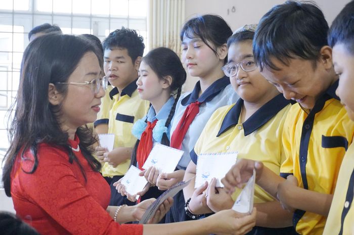  Dành tặng những phần quà cho các em học sinh khiếm thính, khiếm thị và khuyết tật trí tuệ. Ảnh: NGỌC OAI 