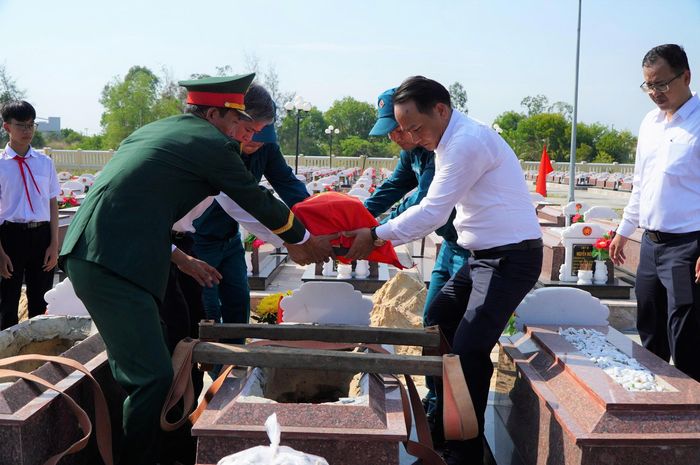 Các đại biểu thực hiện nghi lễ an táng hài cốt liệt sĩ tại Nghĩa trang liệt sĩ Điện Nam