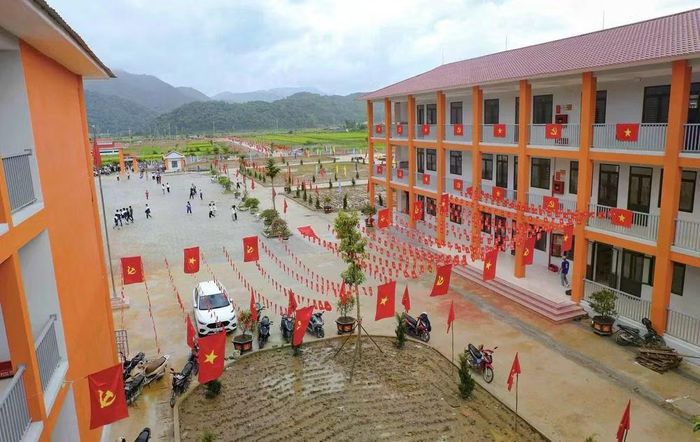 Cờ Đảng, cờ Tổ quốc được trang trí dọc các dãy nhà, tạo sắc màu nổi bật trong khuôn viên Trường Phổ thông nội trú liên cấp Tiểu học và THCS Sam Mứn, tỉnh Điện Biên. Ảnh: Xuân Tư - TTXVN