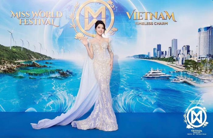 Hoa hậu Phan Phương Oanh lựa chọn váy dạ hội tông trắng bạc với phần thân ôm, phủ họa tiết đính kết. Thiết kế có tà dài phía sau, tạo độ mềm mại khi tạo dáng. Cô búi tóc cao và sử dụng trang sức nhỏ.