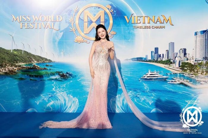 Á hậu Lê Phương Khánh Như chọn váy dạ hội tông hồng nhạt phủ chi tiết bắt sáng. Thiết kế ôm dáng, đi cùng phần tà dài từ vai xuống sàn. Cô buộc nửa tóc, lựa chọn lối trang điểm nhẹ và trang sức nhỏ.