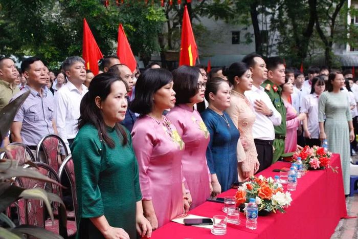 Các đại biểu, giáo viên, học sinh và phụ huynh làm lễ chào cờ.