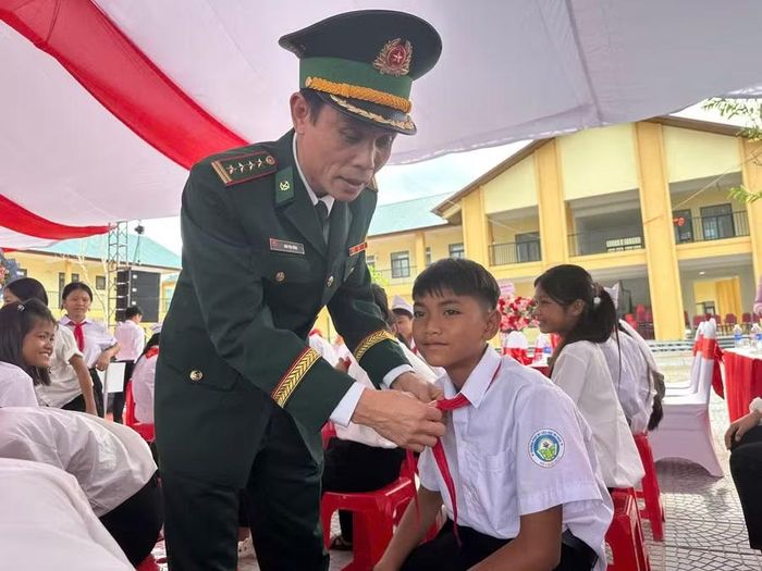 Lãnh đạo Ban chỉ huy BĐBP Quảng Trị sửa lại khăn quàng cho học sinh.