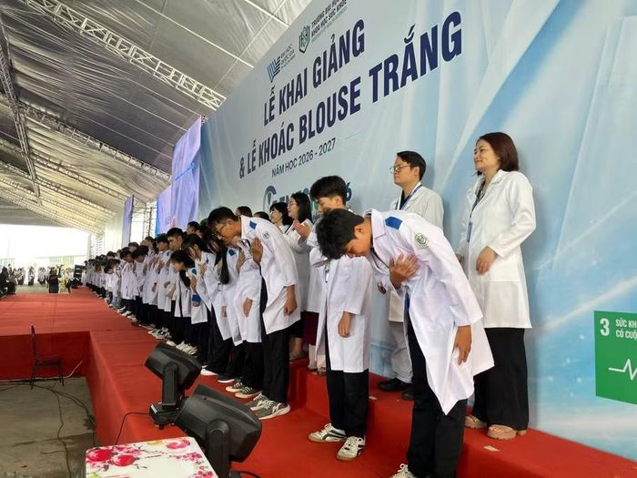 Sinh viên cúi chào hướng về phía các đại biểu, người thân, gia đình tham dự lễ khai giảng. Ảnh: Hà An.