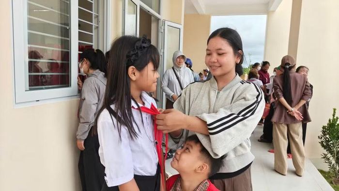 Siu H Atysa chỉnh lại chiếc khăn quàng đỏ cho người em lớp 4.