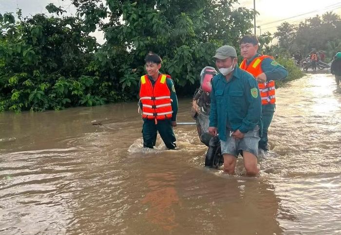 Lực lượng chức năng và người dân xã Hàm Thạnh đưa học sinh vượt qua vùng ngập, kịp dự lễ khai giảng.