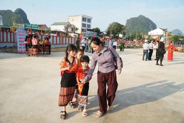 Phụ huynh mang theo con đi khai giảng ở trường mới. Ảnh: Hồ Lài